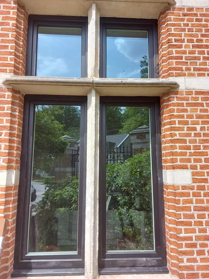 Nieuwe donkere ramen in een klassieke bakstenen gevel met natuursteen