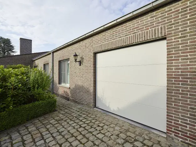 Lichte sectionale garagepoort in een bakstenen woning