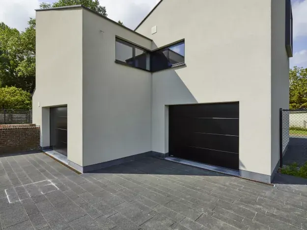 Zwarte sectionale garagepoort in een moderne witte woning