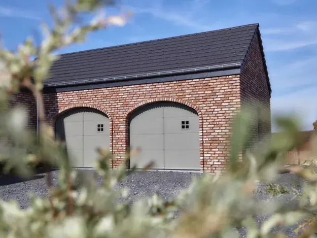 Twee garagepoorten in boogvorm in een landelijke bakstenen garage
