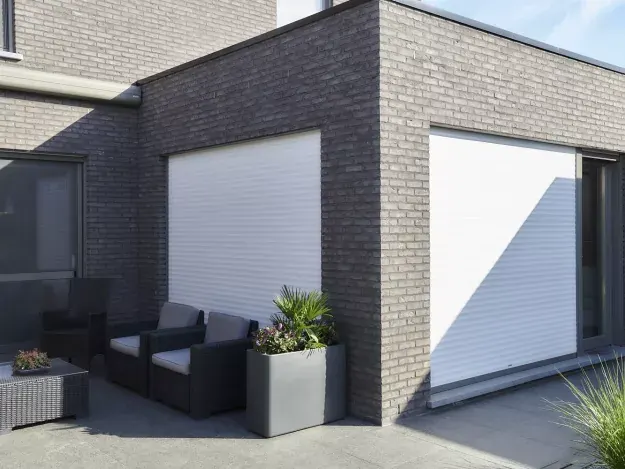 Witte inbouwrolluiken voor de ramen van een moderne woning